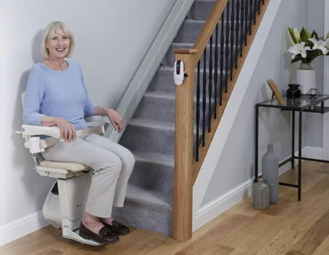 Woman smiling while using a Handicare stairlift in Arden, NC